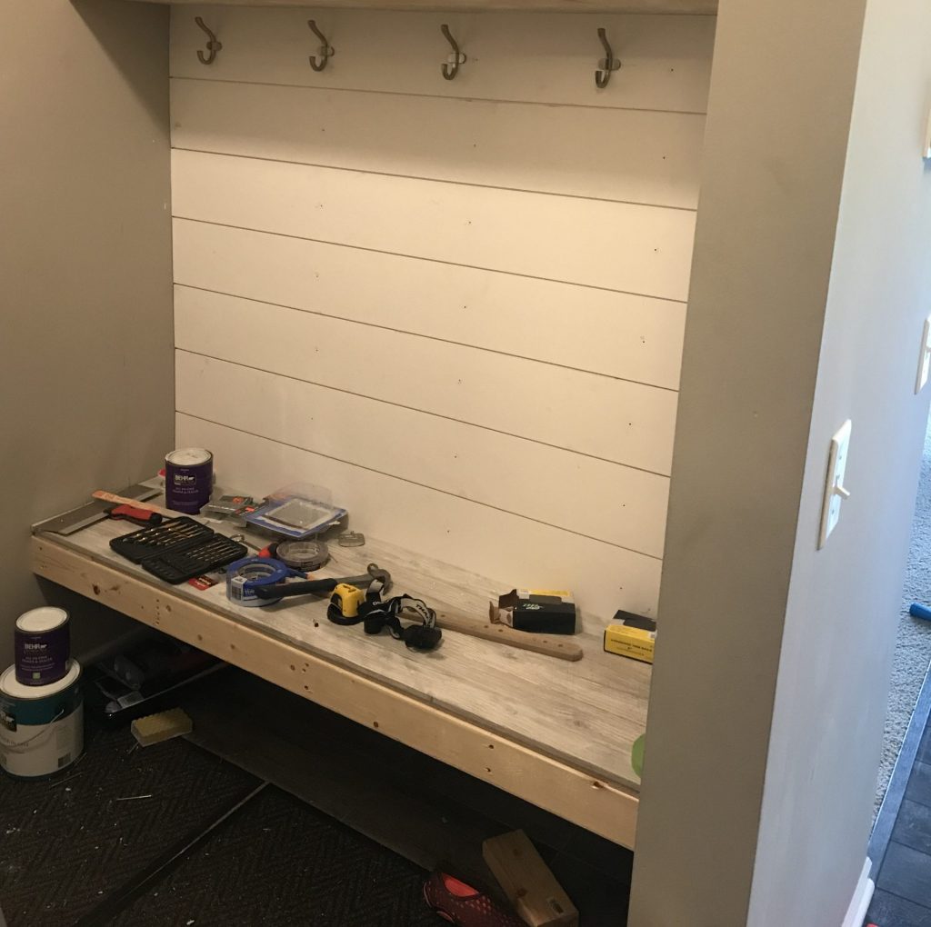 Shiplap and hooks mounted in mud room design